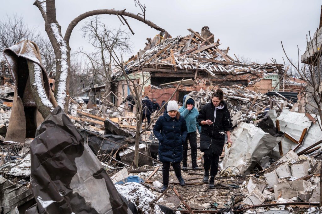 Women walk among remains of residential buildings destroyed by shelling, as Russia's invasion of Ukraine continues, in Zhytomyr, Ukraine March 2, 2022. REUTERS/Viacheslav Ratynskyi