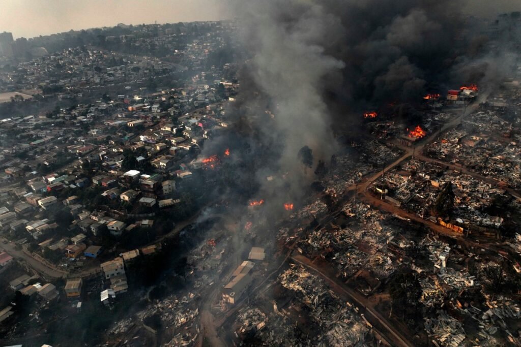 Aerial view of the forest fire that affects the hills of the city of Viña del Mar in the Las Pataguas sector, Chile, taken on February 3, 2024. The region of Valparaoso and Viña del Mar, in central Chile, woke up on Saturday with a partial curfew to allow the movement of evacuees and the transfer of emergency equipment in the midst of a series of unprecedented fires, authorities reported. (Photo by Javier TORRES / AFP)