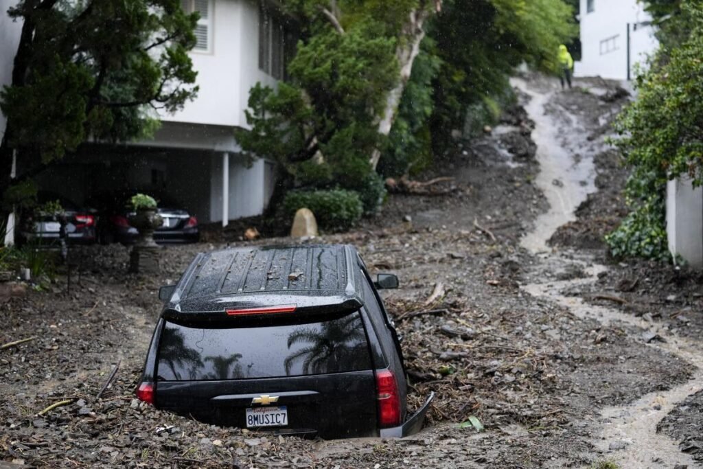 An SUV sits buried by a mudslide, Monday, Feb. 5, 2024, in the Beverly Crest area of Los Angeles. A storm of historic proportions unleashed record levels of rain over parts of Los Angeles on Monday, endangering the city’s large homeless population, sending mud and boulders down hillsides dotted with multimillion-dollar homes and knocking out power for more than a million people in California. (AP Photo/Marcio Jose Sanchez) (Marcio Jose Sanchez / Associated Press)